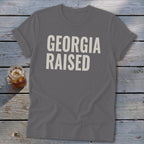 Gray t-shirt with "GEORGIA RAISED" text in cream.