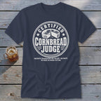 Dark blue t-shirt featuring a circular white graphic that reads CERTIFIED CORNBREAD JUDGE with cornbread illustration.