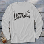 White long-sleeve shirt with "Lemme seeit" text in black brush strokes.