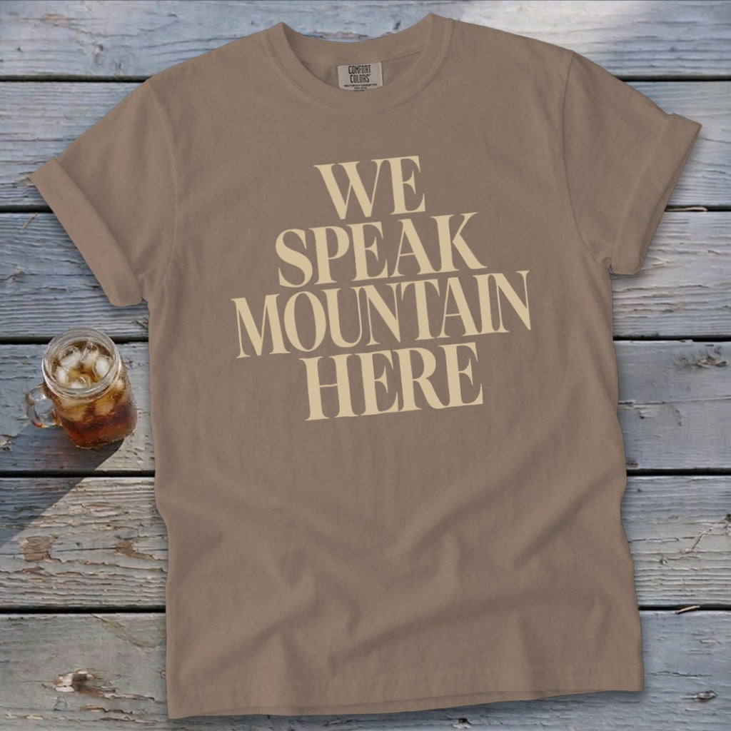 Brown t-shirt with "WE SPEAK MOUNTAIN HERE" text and a glass of iced tea.