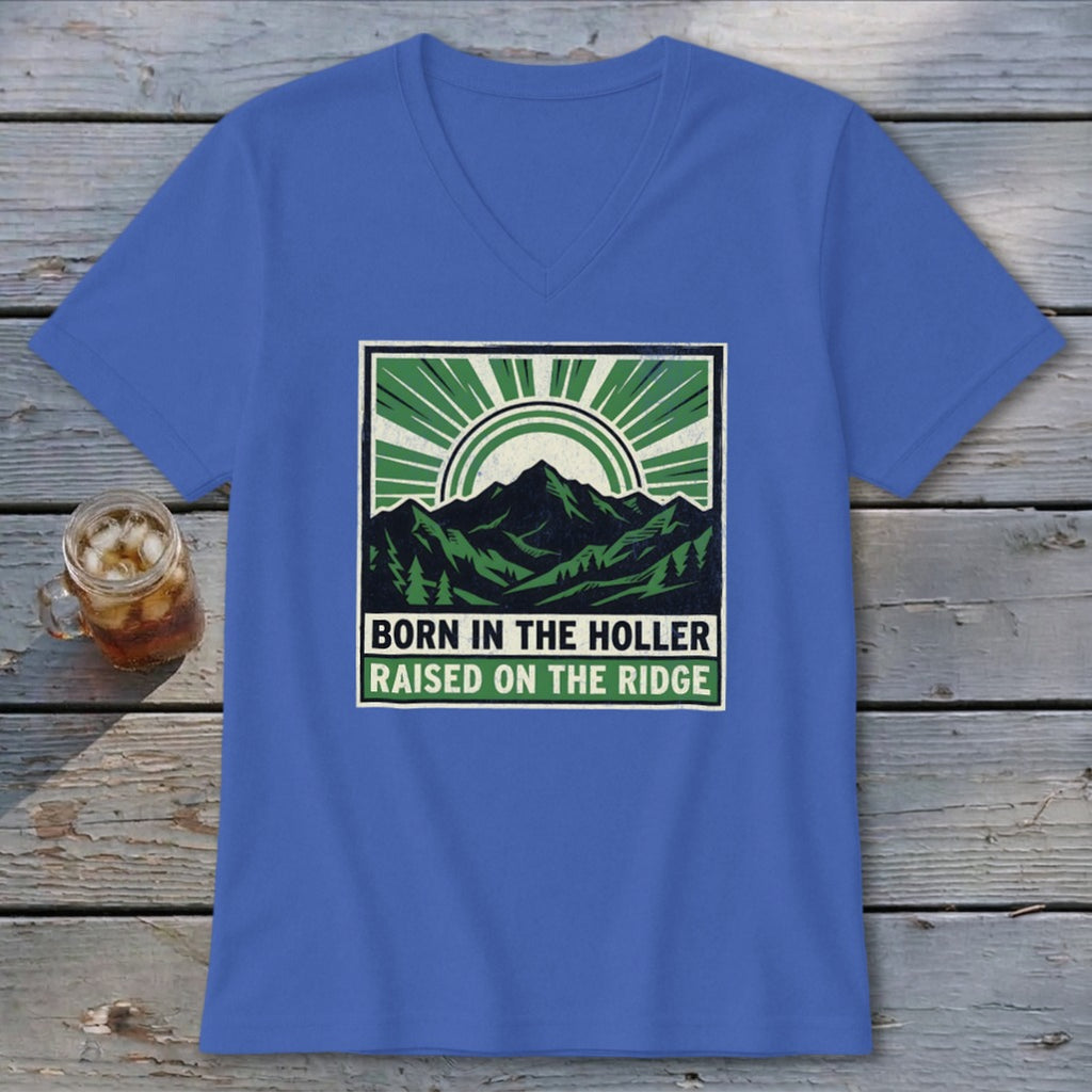 A blue V-neck t-shirt featuring a green and black graphic of mountains, trees, and the text "BORN IN THE HOLLER RAISED ON THE RIDGE."