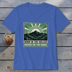 A blue V-neck t-shirt featuring a green and black graphic of mountains, trees, and the text "BORN IN THE HOLLER RAISED ON THE RIDGE."