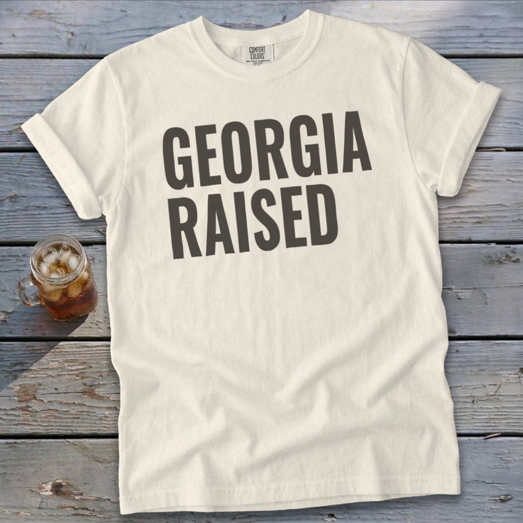 Cream Comfort Colors t-shirt with "GEORGIA RAISED" printed in dark gray.