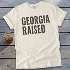 Cream Comfort Colors t-shirt with "GEORGIA RAISED" printed in dark gray.
