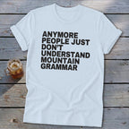 Light blue t-shirt with black text that reads "Anymore people just don't understand mountain grammar."
