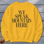 Yellow sweatshirt with "WE SPEAK MOUNTAIN HERE" text in black.