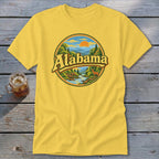 Yellow t-shirt with "Alabama" text and scenic woodland, river, and deer graphic.