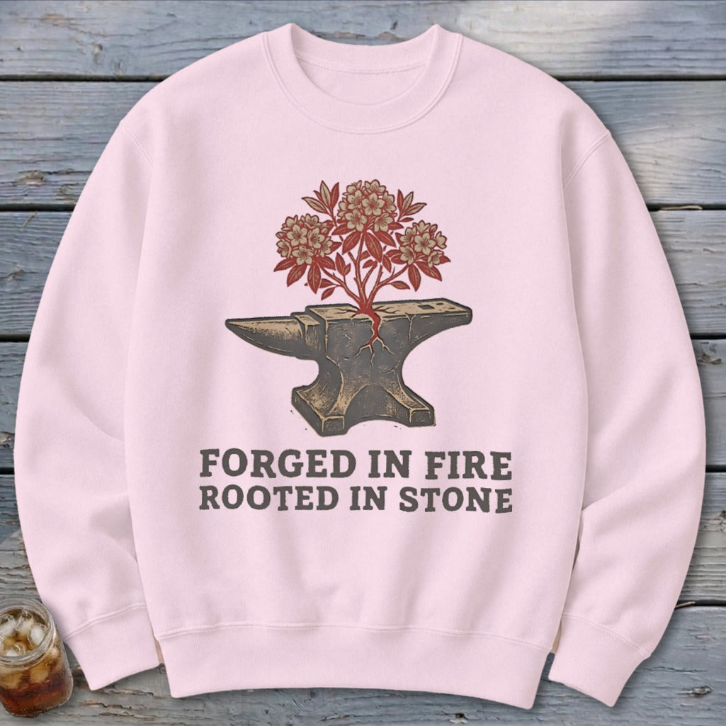 Pink sweatshirt with an anvil and flowering branches graphic and text.