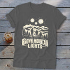 A dark gray t-shirt featuring a mountain graphic and the text Brown Mountain Lights.