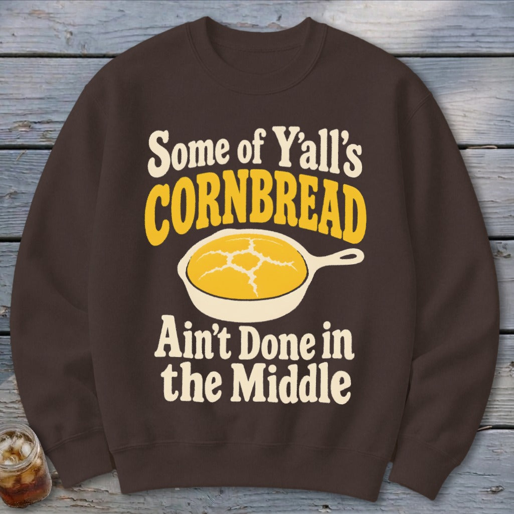 Brown crewneck sweatshirt printed with a vintage illustration of a skillet of cornbread and text.