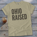 Tan t-shirt with large dark gray text reading "OHIO RAISED".