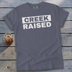 Grey t-shirt with white text that reads "CREEK RAISED".
