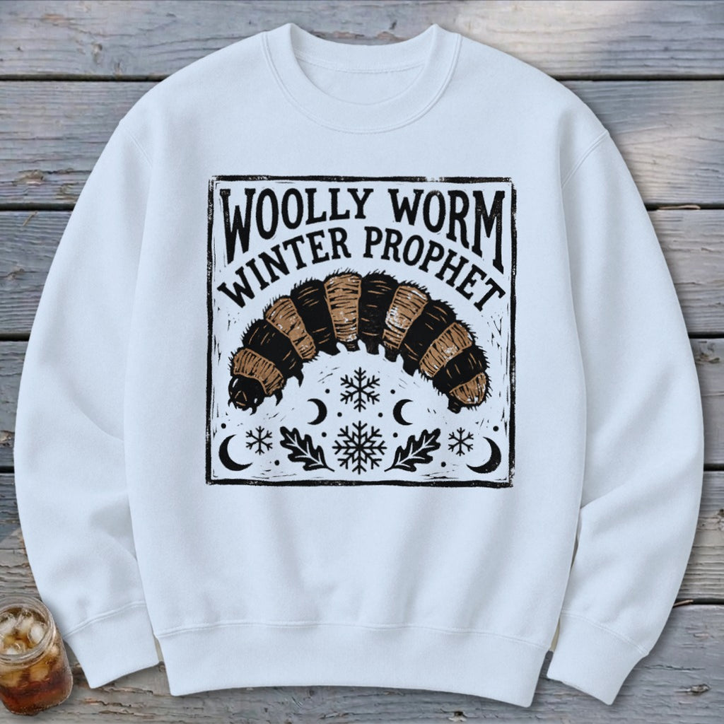 A white crewneck sweatshirt featuring a black graphic of a woolly worm with text reading Woolly Worm Winter Prophet.