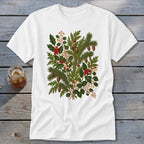 White t-shirt with a detailed botanical illustration of pine sprigs, holly, pinecones, and berries.