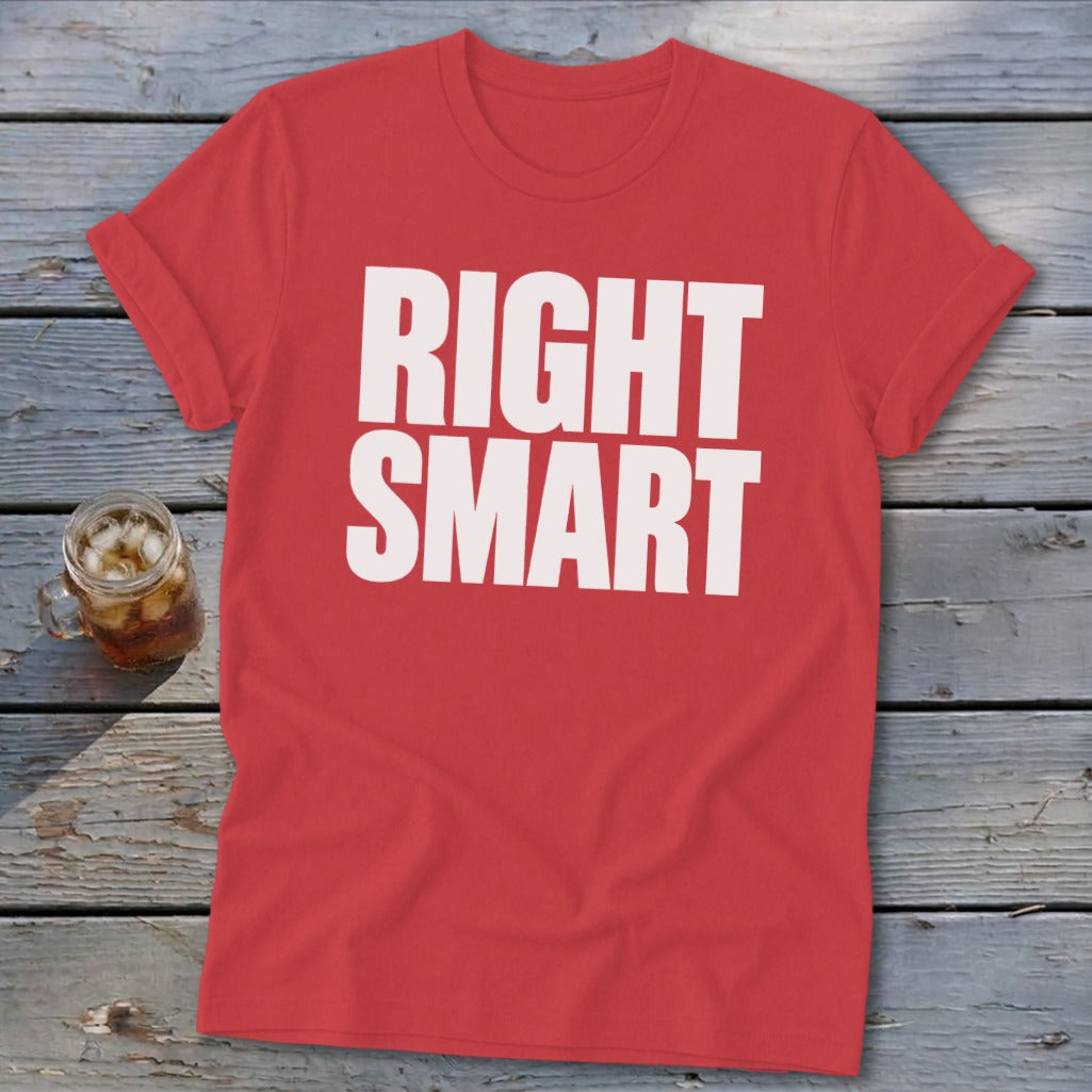 Red crewneck t-shirt with rolled sleeves, featuring the white block text RIGHT SMART, laid on a weathered wooden surface.