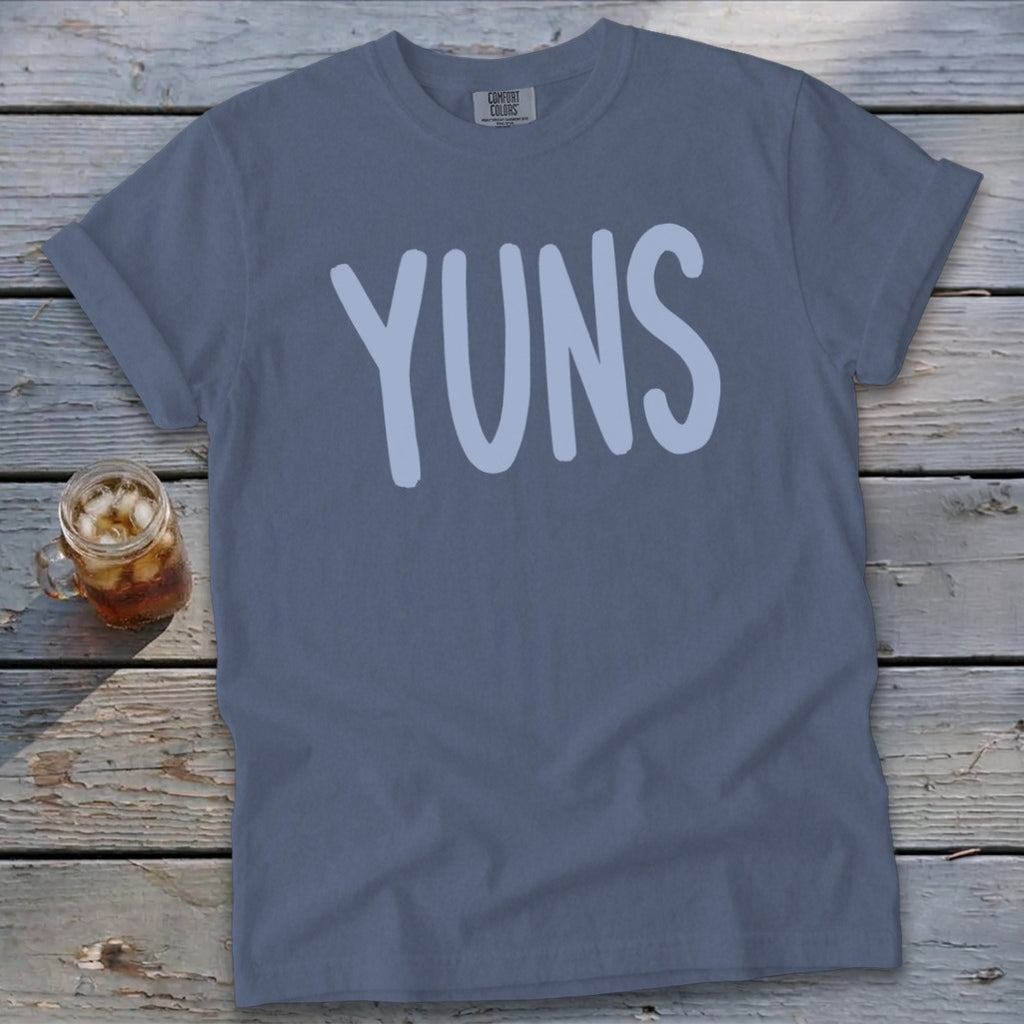 Slate blue Comfort Colors t-shirt with "YUNS" in a light blue font.
