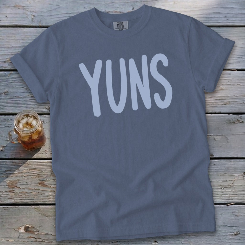 Slate blue Comfort Colors t-shirt with "YUNS" in a light blue font.