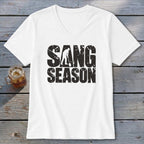 A white V-neck t-shirt featuring the distressed black text "SANG SEASON" and a graphic of a person digging.