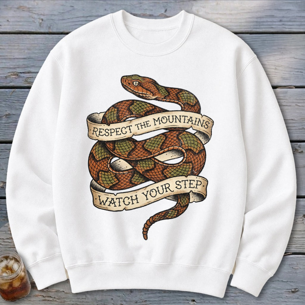 White sweatshirt with coiled snake graphic and banners reading "Respect the Mountains" and "Watch Your Step."