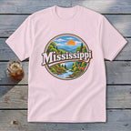 Pink t-shirt with a circular graphic of a river, mountains, and deer, with the word Mississippi.