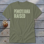 Olive green t-shirt with "PENNSYLVANIA RAISED" text in light beige.