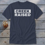 Navy t-shirt with white text that reads "CREEK RAISED".