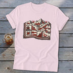 Light pink t-shirt featuring a stylized graphic of a mountain landscape combined with a patchwork quilt.