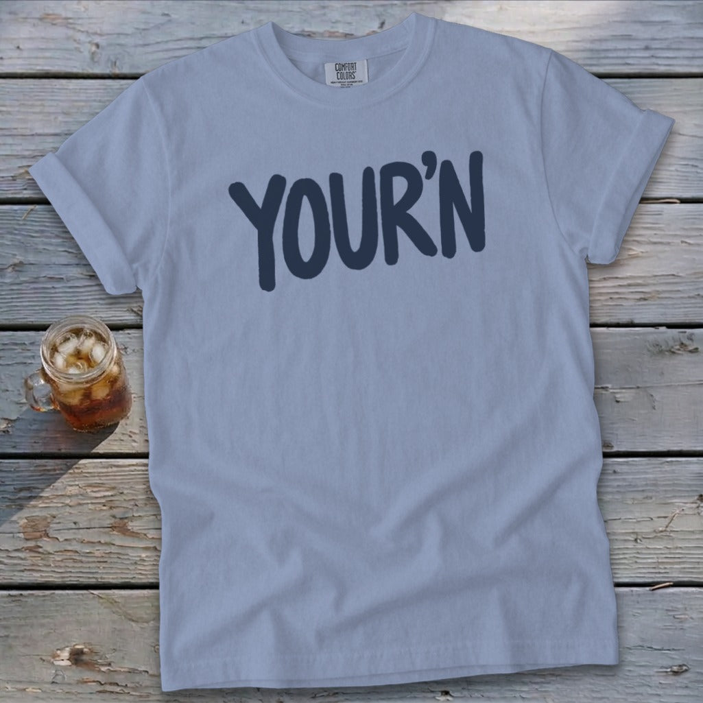 Light blue t-shirt with "YOUR'N" graphic and a glass of iced tea.