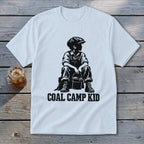 White t-shirt with "Coal Camp Kid" text and silhouette of a boy with a bucket.
