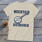 Beige t-shirt featuring a blue graphic of a banjo and the text Mountain Echoes.