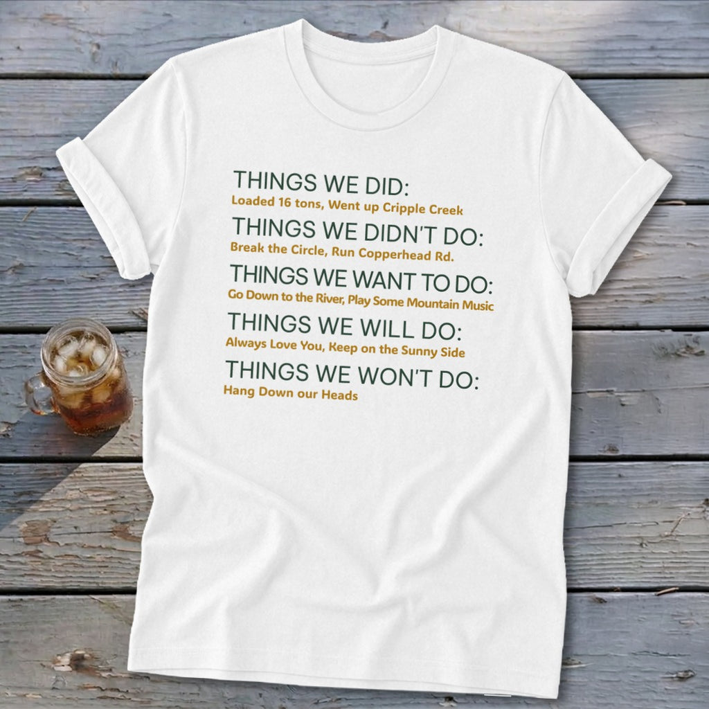 White t-shirt with green and orange text listing "Things We Did" and other categories.