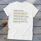 White t-shirt with green and orange text listing "Things We Did" and other categories.