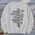A light gray sweatshirt features a rustic wooden signpost graphic with humorous directional distances.
