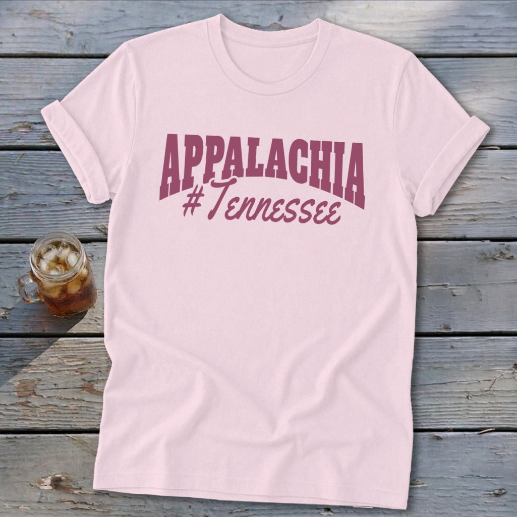 Pink t-shirt with "APPALACHIA #Tennessee" text on a rustic wooden surface.