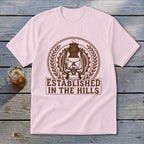 Pink t-shirt with "Established In The Hills" text and a lantern graphic.