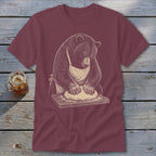 Bear wearing apron kneading dough on wooden board.