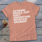 Peach t-shirt with white text: "Anymore people just don't understand mountain grammar."