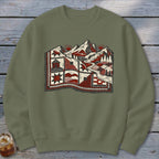 An olive green crewneck sweatshirt featuring a graphic of mountains and a quilted landscape.