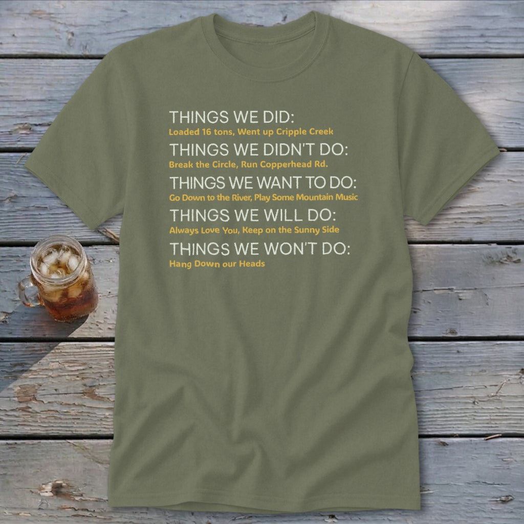 Olive green t-shirt with white and yellow text listing "Things We Did," "Things We Didn't Do," etc.