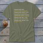Olive green t-shirt with white and yellow text listing "Things We Did," "Things We Didn't Do," etc.