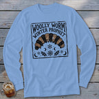 A light blue long-sleeve t-shirt features a black block-print graphic of a woolly worm and text reading Woolly Worm Winter Prophet.
