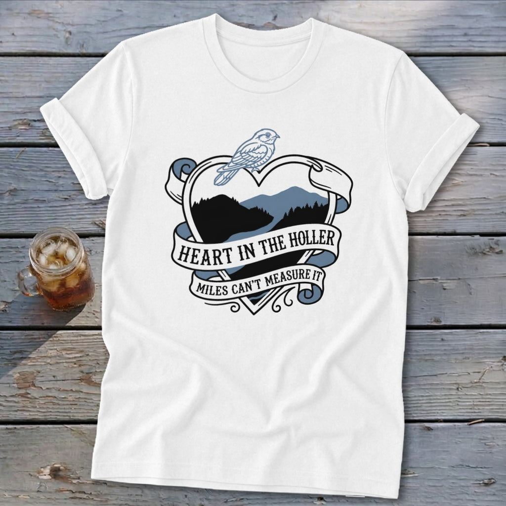 White t-shirt with heart graphic, bird, and text "Heart in the Holler Miles Can't Measure It".