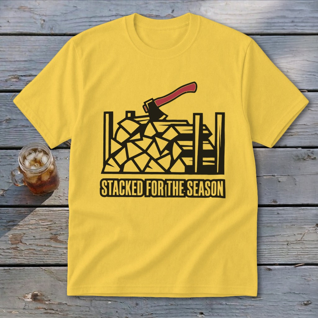 Yellow t-shirt with black graphic of stacked firewood and axe; text "STACKED FOR THE SEASON".