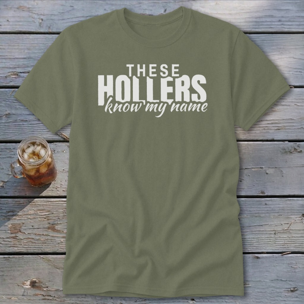 Olive green t-shirt with white text "THESE HOLLERS know my name".