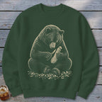 Dark green sweatshirt with illustration of a bear carving wood with a knife.
