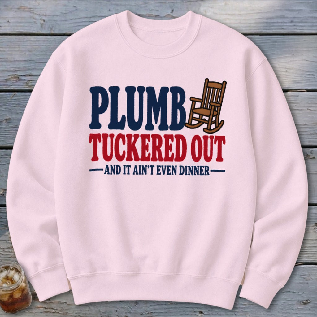 Pink sweatshirt with "PLUMB TUCKED OUT" text and a rocking chair graphic.