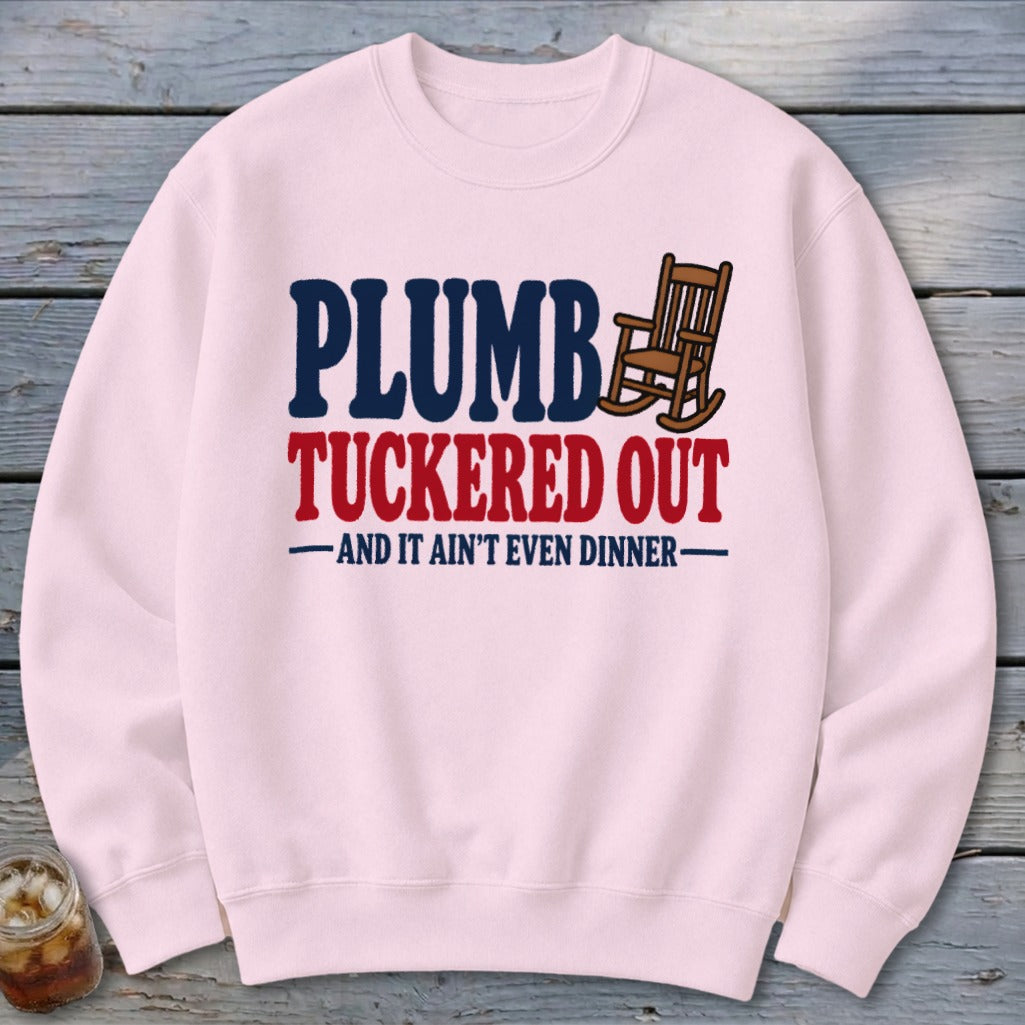 Pink sweatshirt with "PLUMB TUCKED OUT" text and a rocking chair graphic.