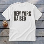 White t-shirt with "NEW YORK RAISED" text and a glass of iced tea.