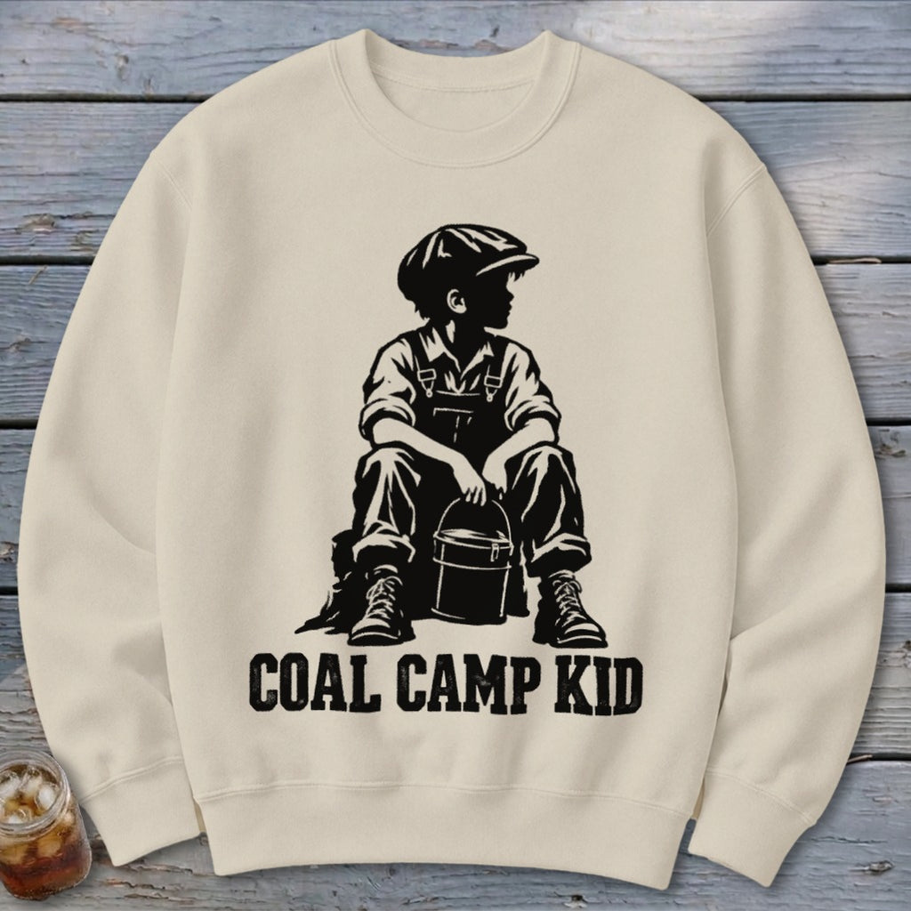 Crewneck sweatshirt with black graphic of a boy in overalls and cap holding a bucket, text reads "Coal Camp Kid."