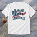 White t-shirt with distressed American flag and text "Alabama Raised American Made".